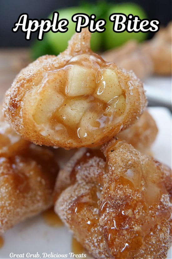 A small white plate with 4 apple pie bites on it with a bite taken out of one.