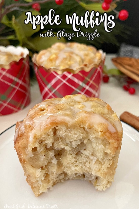 An apple muffin topped with glaze, with a bite taken out of it, sitting on a white plate.