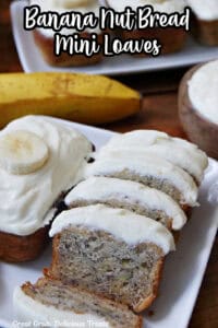 A white plate with two mini banana nut breads on it and one that has been sliced into bite-size pieces.