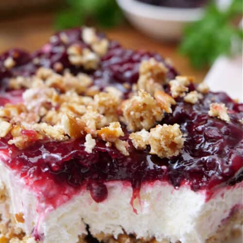 A close up of a serving of blackberry pretzel dessert with a bite taken out.
