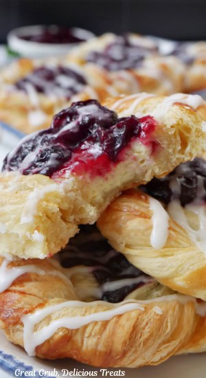 A close up of more pastries with the top one with a bite taken out of it.