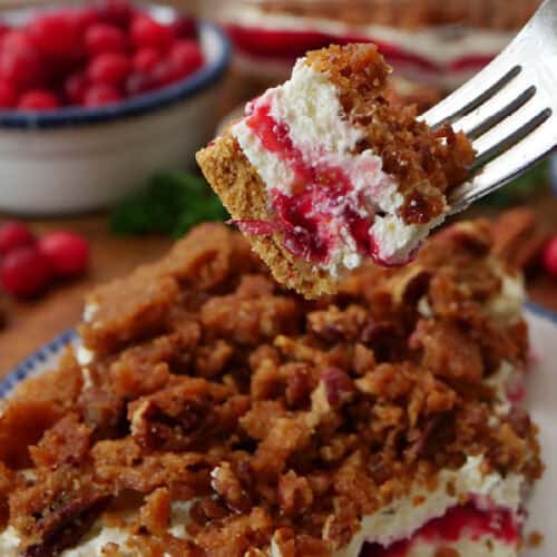 A fork with a bite of cream cheese cranberry orange dessert on it.