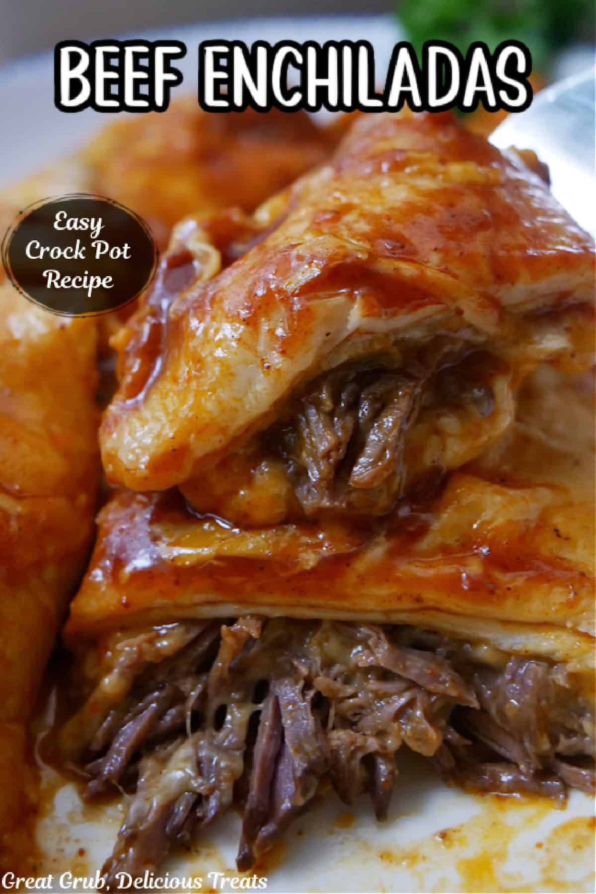 A close up photo of beef enchiladas on a white plate showing the beef and cheese inside the tortillas.