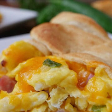 A white plate with a breakfast crescent on it with a few bites taken out.