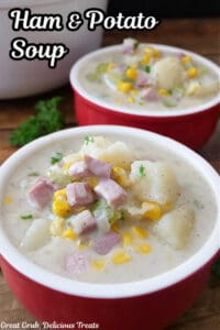 Two red soup bowls filled with a serving of ham and potato soup.