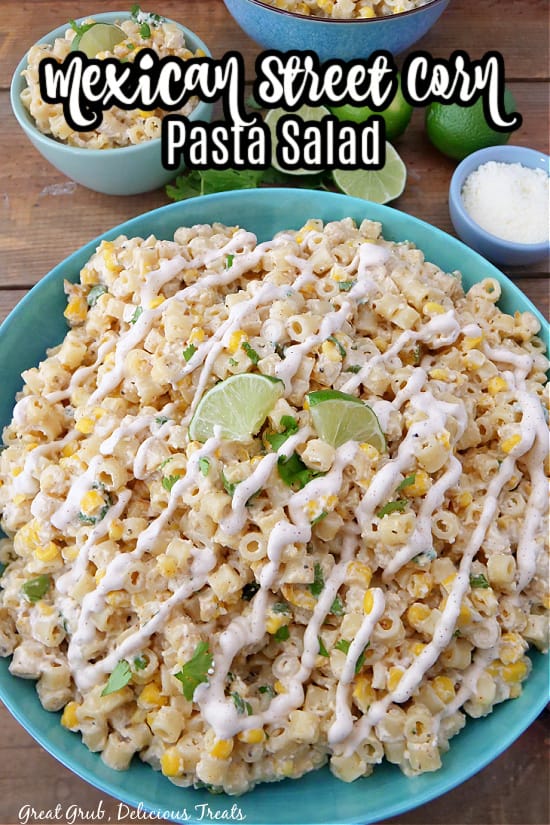A large blue bowl filled with pasta salad and drizzled with street corn dressing.
