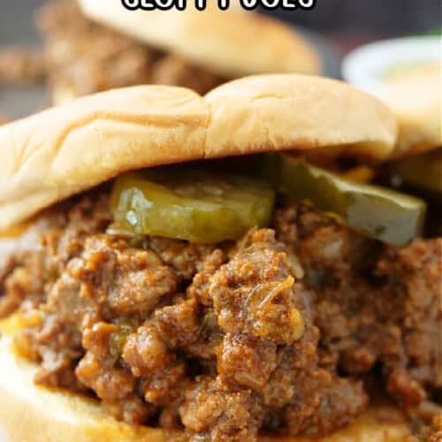 A sloppy joe on a counter showing the meat and pickles in a toasted bun with the title of the recipe at the top.