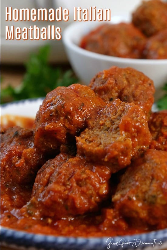 Homemade Italian Meatballs stacked up on each other on a white plate.