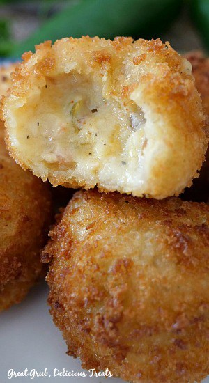 Loaded Mashed Potato Bites are a twist to your favorite potato appetizers and will be a hit with family and friends. A close up of a loaded mashed potato bite with a bite taken out of it.
