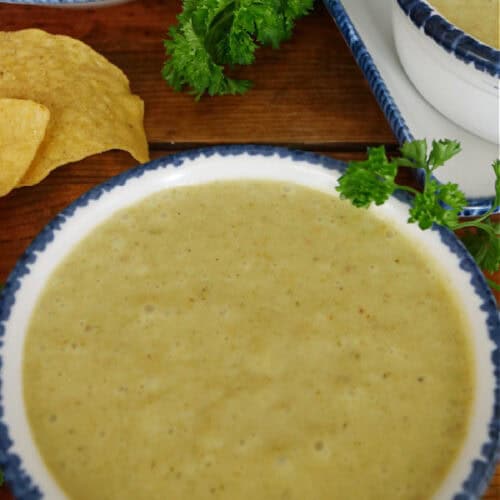 A white bowl with blue trim filled with poblano sauce.