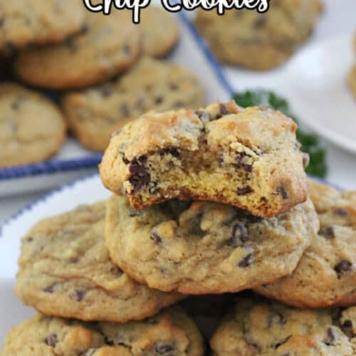 A white counter with pumpkin chocolate chip cookies on it.