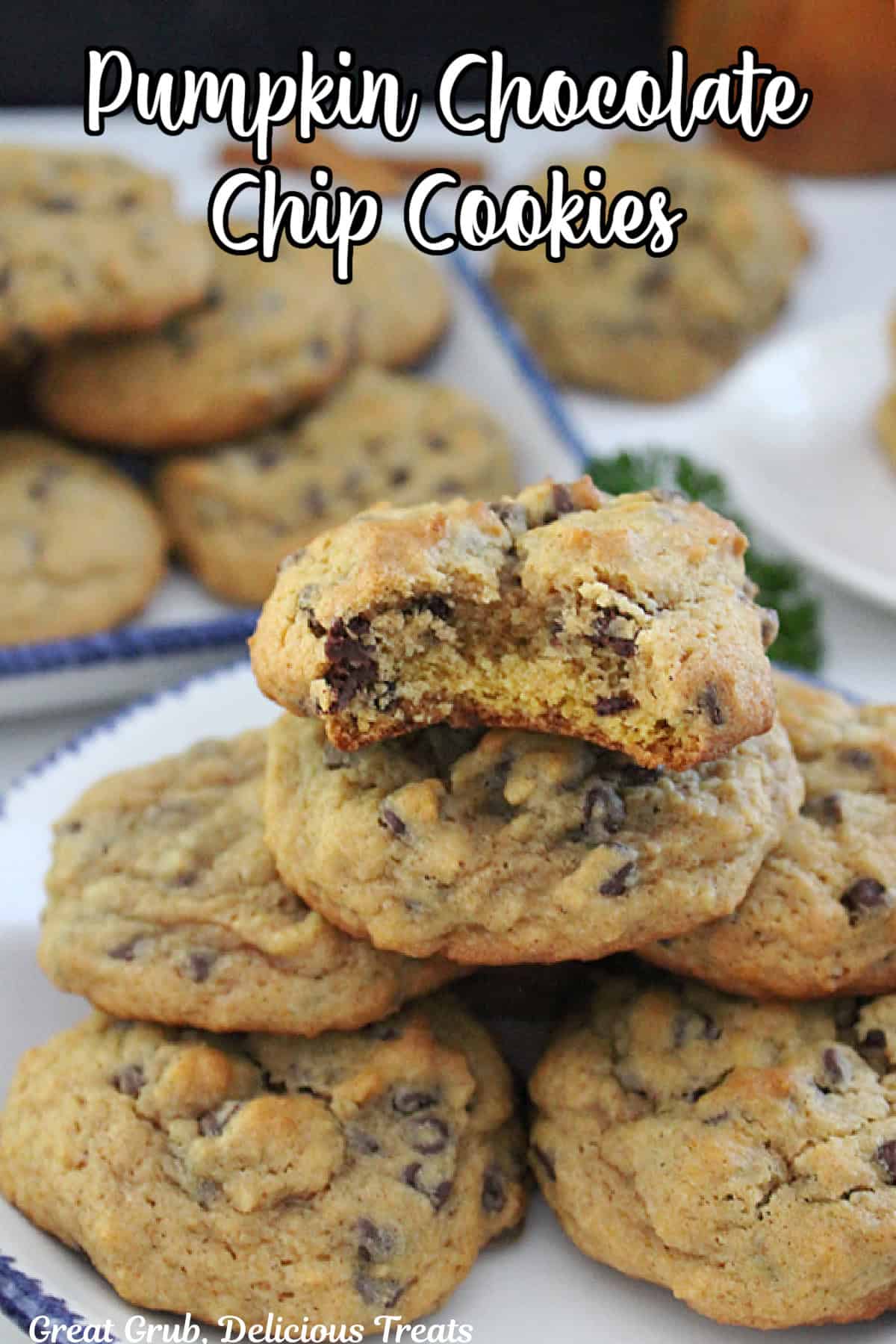 A white counter with pumpkin chocolate chip cookies on it.
