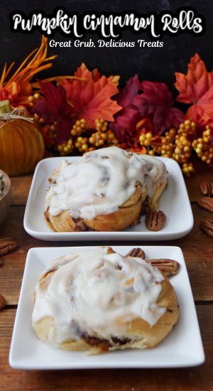 Two white small square plates with pumpkin cinnamon rolls on them.