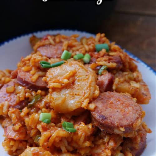 A blue trimmed white bowl with a serving of jambalaya.