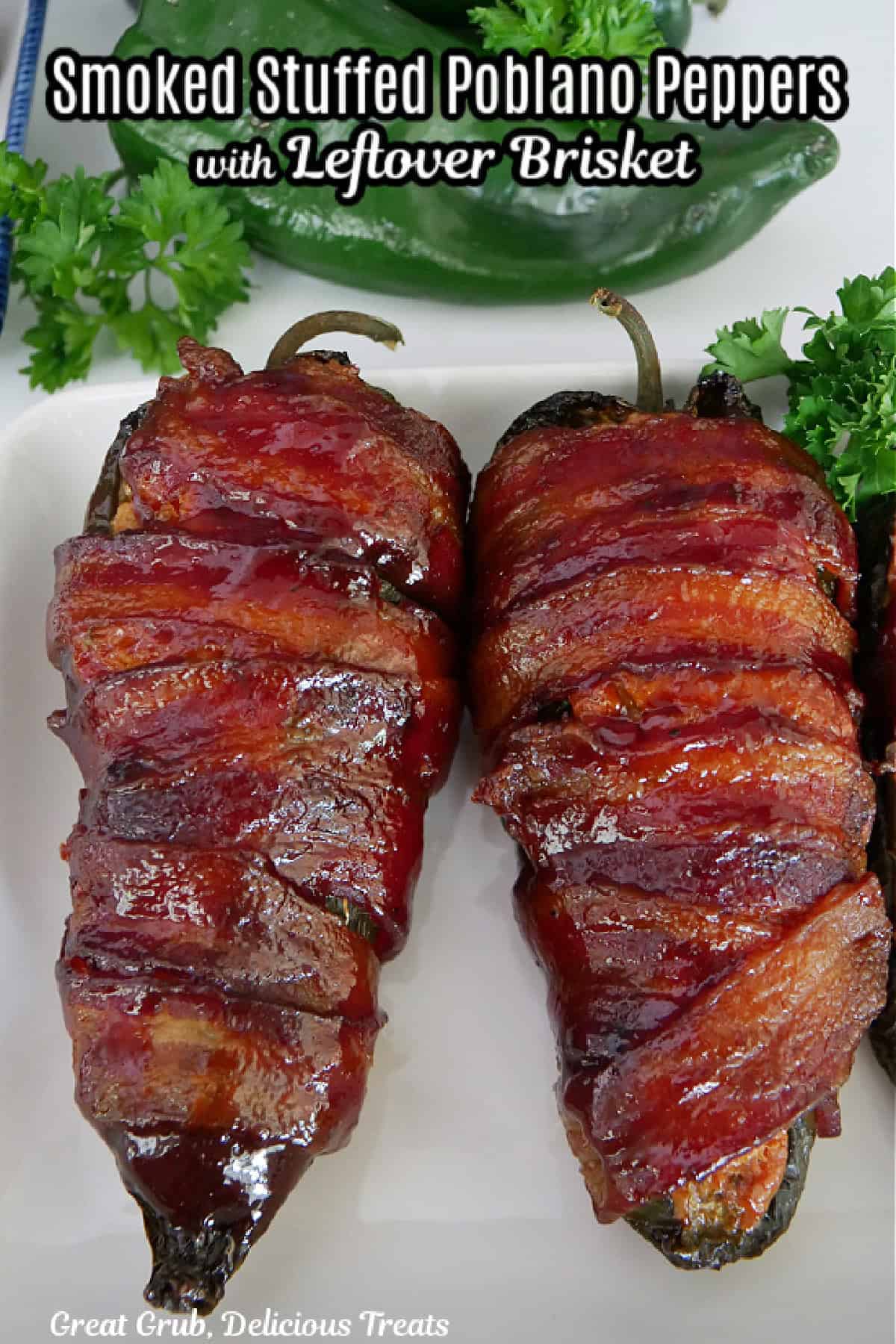 Two smoked bacon wrapped stuffed poblano peppers on a white plate with the title in text at the top.